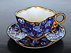 a cup and saucer sitting on top of a black table next to each other