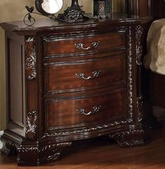 a bedroom with a bed, night stand and mirror on top of the dressers