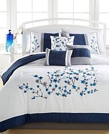 a bed with blue and white comforters in a room