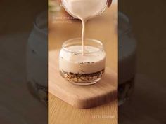 a person pouring milk into a glass jar