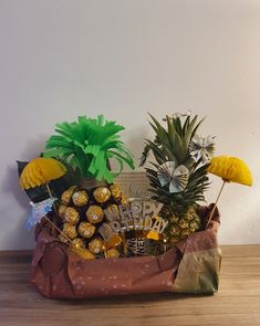 a basket filled with pineapples, bananas and other items on top of a wooden table