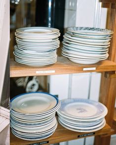 the shelves are filled with plates and bowls