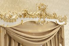 an ornate gold and white drapes in front of a window with draperies on it