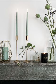 candles and vases are sitting on a mantle