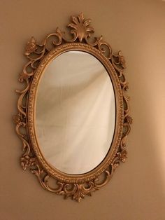 an ornate gold framed mirror on the wall