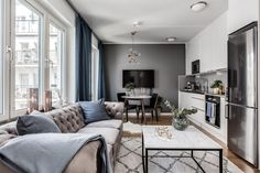 a living room filled with furniture and a flat screen tv mounted to the wall next to a window