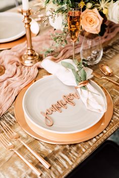 a table set with gold and white place settings