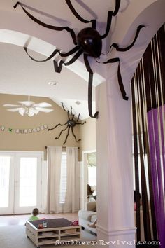 a spider hanging from the ceiling in a living room