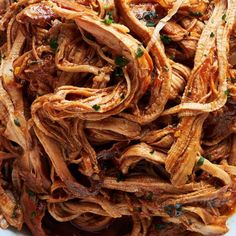 a white bowl filled with shredded meat and sauce