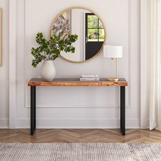 a living room with a table, mirror and plant