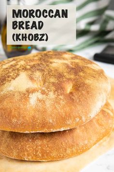 two round breads sitting next to each other on top of a cutting board with the words moroccan bread khobz