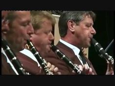 a group of men in vests and ties playing musical instruments