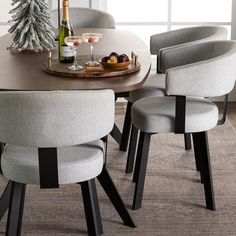 a dining room table with chairs and a bottle of wine