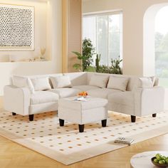 a living room with white furniture and wood floors