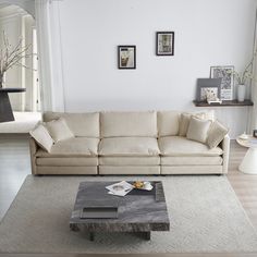 a living room with a couch, coffee table and pictures on the wall