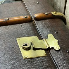 an old suitcase with brass hardware and wooden handles