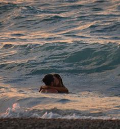 two people in the ocean kissing each other