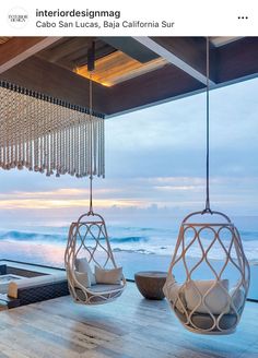 two hanging chairs in front of an ocean view