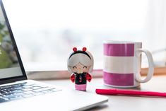 Momiji doll standing next to laptop and mug Gifts For Best Friends