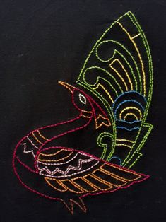 a black t - shirt with a colorful bird embroidered on it