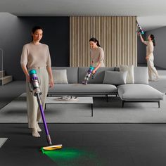 two women are using vacuums to clean the floor