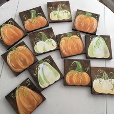 painted pumpkins are arranged on wooden blocks to look like they have been placed together