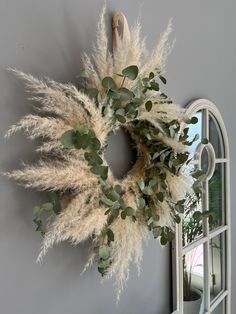 a wreath is hanging on the wall next to an open window