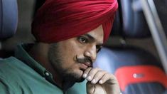 a man with a red turban sitting in a car looking off to the side