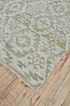 a green and white rug on top of a wooden floor