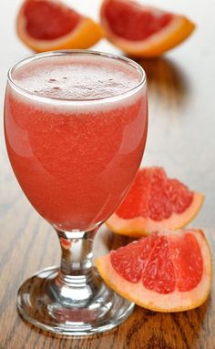 grapefruit and orange juice in a glass on a wooden table