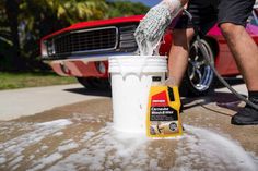 a man washing his car with a foamy bucket