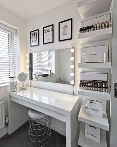 a white vanity with lots of lights on top of it and a mirror in the corner