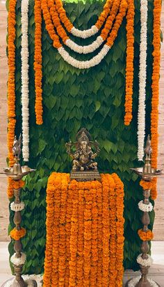 an arrangement of orange and white flowers on display in front of a mandap