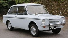 an old white car is parked on the street