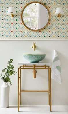 a bathroom sink with a mirror above it and a plant on the counter next to it