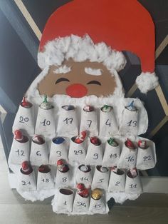 a paper bag with a santa clause on it and some candy in front of it