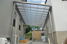 an open walkway leading to a building with lots of storage containers on the ground and in front of it