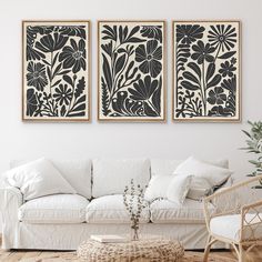 two black and white paintings hanging on the wall above a couch in a living room