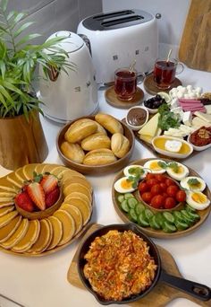 a table topped with plates and bowls filled with food next to an air fryer