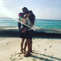 a man and woman embracing on the beach