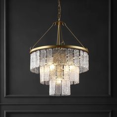 a chandelier hanging from the ceiling in a room with black walls and flooring