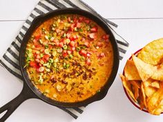 a skillet filled with salsa and chips next to a bowl of tortilla chips