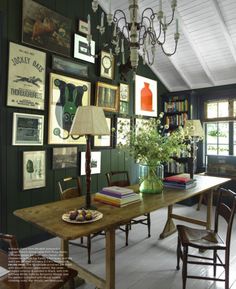 an image of a dining room with green walls and pictures on the wall above it