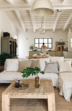 a living room filled with furniture and a wooden table in front of a white couch