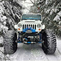 a white jeep driving down a snow covered road