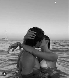 two people in the water kissing each other