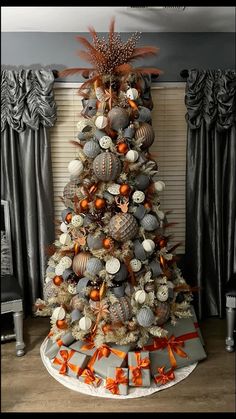 a decorated christmas tree with orange and silver ornaments