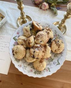 a white plate topped with cookies on top of a table next to a candle holder