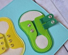 two pairs of shoes made out of felt on top of a piece of blue paper