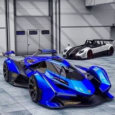 two blue sports cars parked in a garage